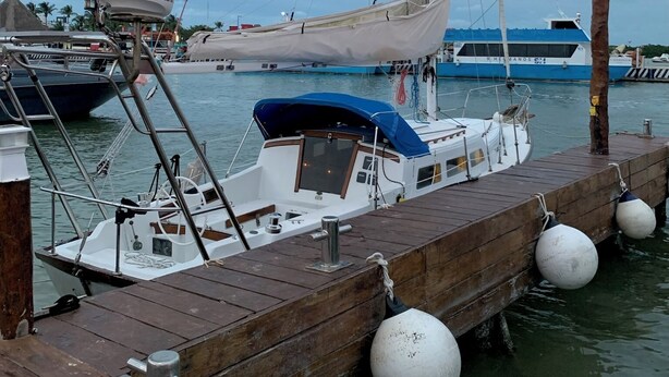 Een steiger met een zeilboot, een kleinere boot en een Raymarine radarsysteem.