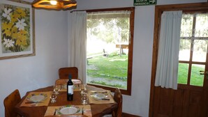 A dining area with a table set for four, a bottle of wine, and a sign indicating an emergency exit.