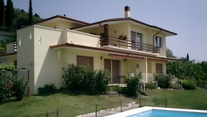A two-story house with a swimming pool in front. - Vacation apartment Lake Garda Cavaion Bardolino with pool (Cavaion)