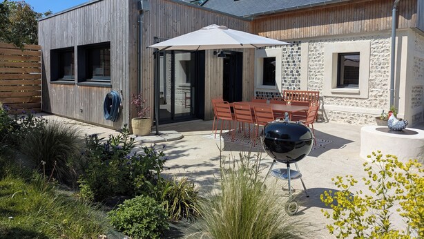 A modern house with a patio, outdoor seating, and a barbecue grill. - La Maison d'Anita at Le Tilleul, 4 km from Etretat, ideal for families or friends. (Le Tilleul)