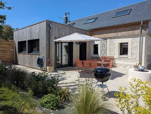 A modern house with a patio, outdoor seating, and a barbecue grill. - La Maison d'Anita at Le Tilleul, 4 km from Etretat, ideal for families or friends. (Le Tilleul)
