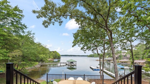 A deck with a table and chairs overlooking a lake, docks, and boats. - Game Room, 3 Kings, Guest Suite, Lakefront (Mooresville)