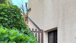 Un edifici amb façana beix, una tanca de fusta i una finestra petita.