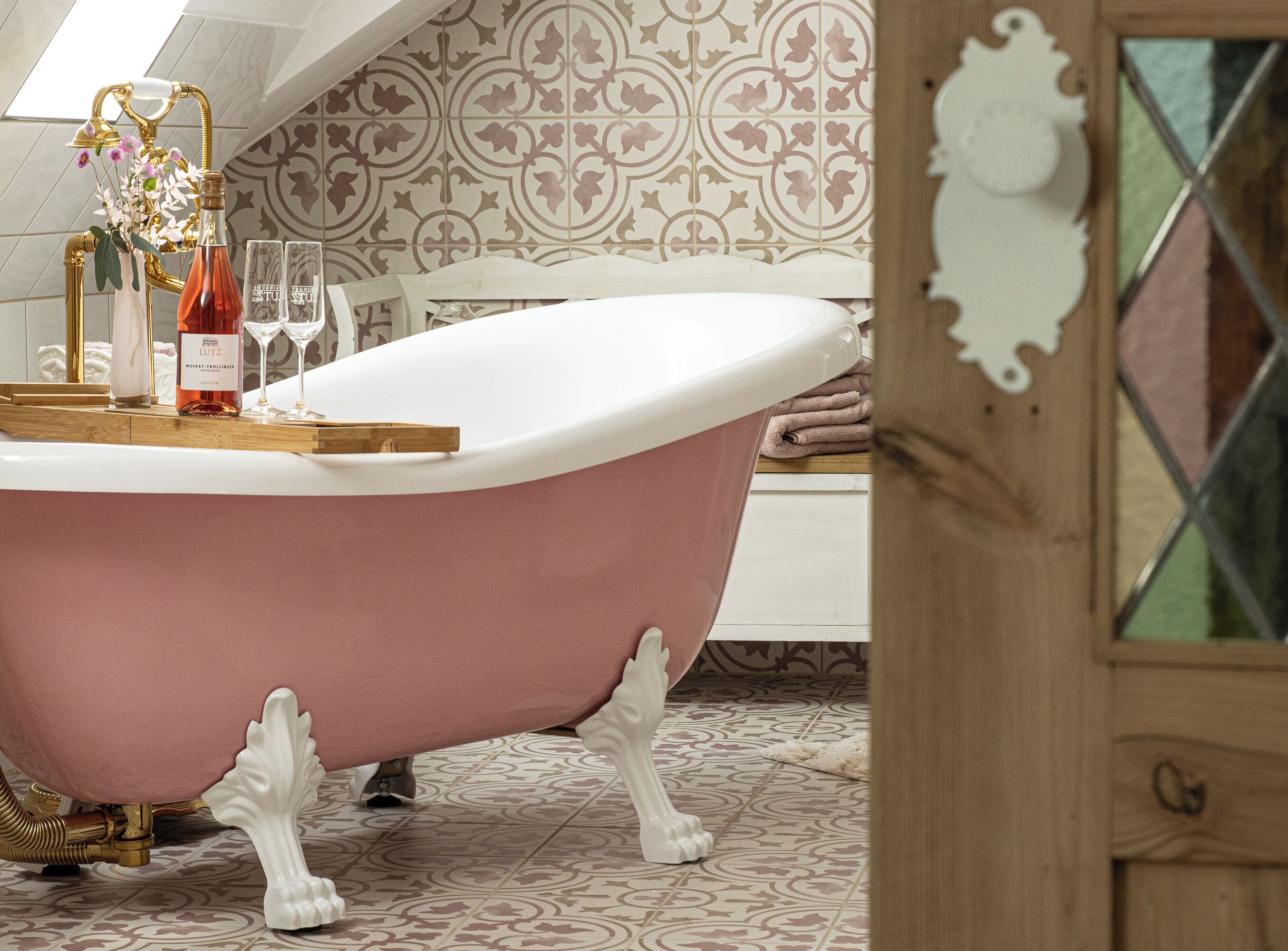 Un baño de estilo vintage con una bañera independiente, un perchero para toallas y una zona de ducha decorativa.