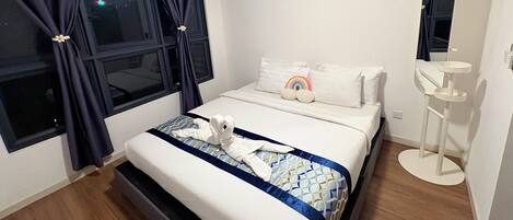 Una habitación de hotel con cama, mesita de noche, espejo y ventana con cortinas.