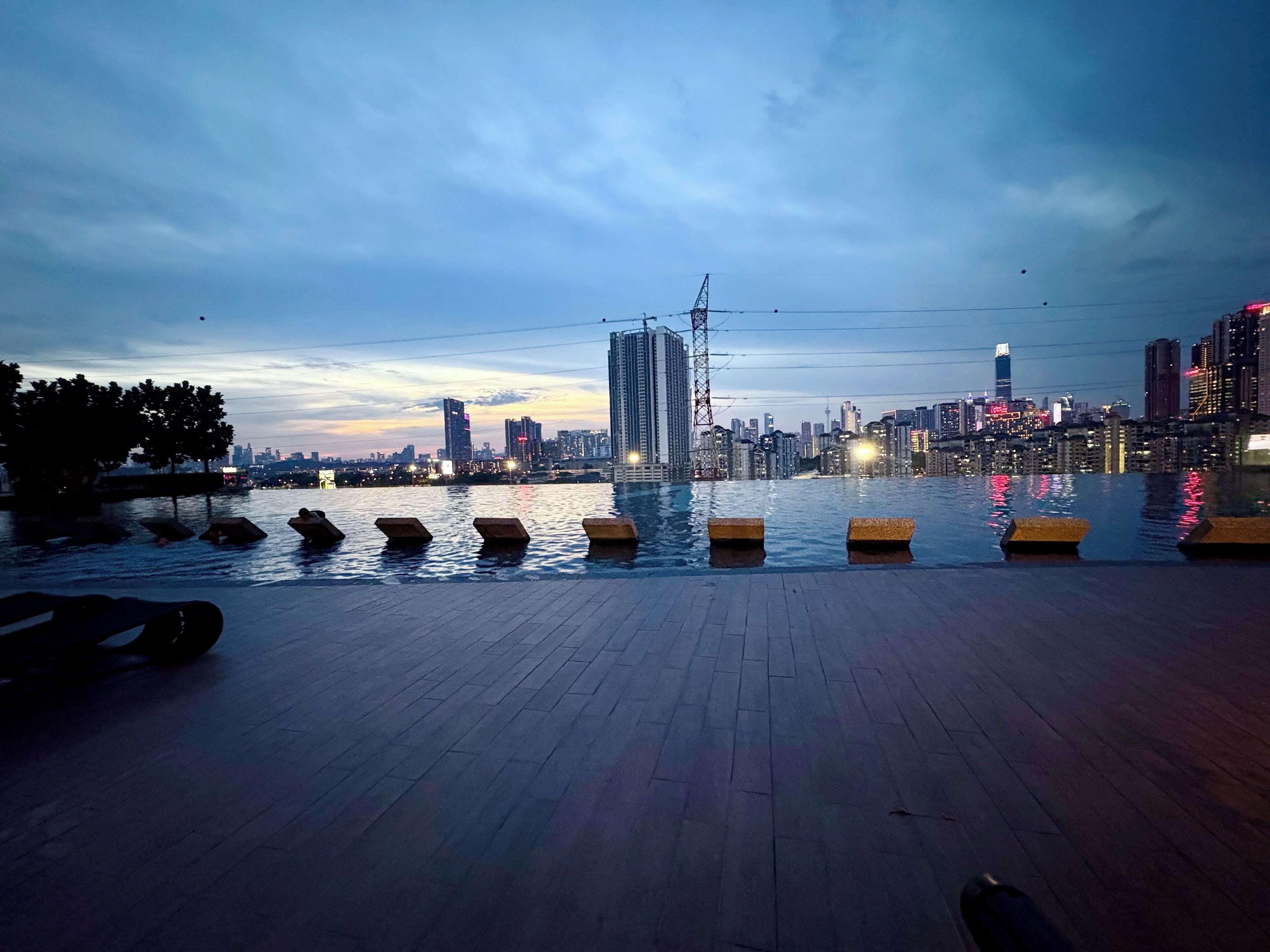 A waterfront promenade with a city skyline in the background.