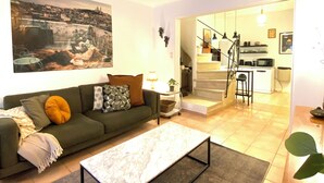A living room with a sofa, a coffee table, and a painting on the wall. - Typical house in the historic center of the Arles bullring (Arles)