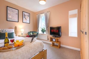 Relax in a comfortable room with a plush bed, bedside table, and TV featuring Netflix.