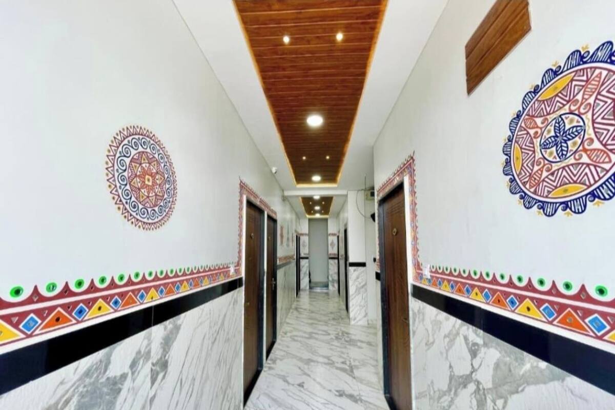 A hallway with marble flooring, wooden ceiling, and patterned wall decorations.