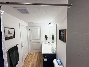 Bathroom features a sink, mirror, toilet, and towel rack.