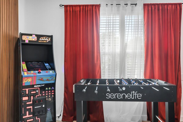 A foosball table with the brand 'serenelife' and a retro arcade machine with 'Pac-Man' branding. - Cozy Home near NRG, Medical Centre, Toyota Centre with Hot Tub Spa, Arcade, BBQ (Houston)