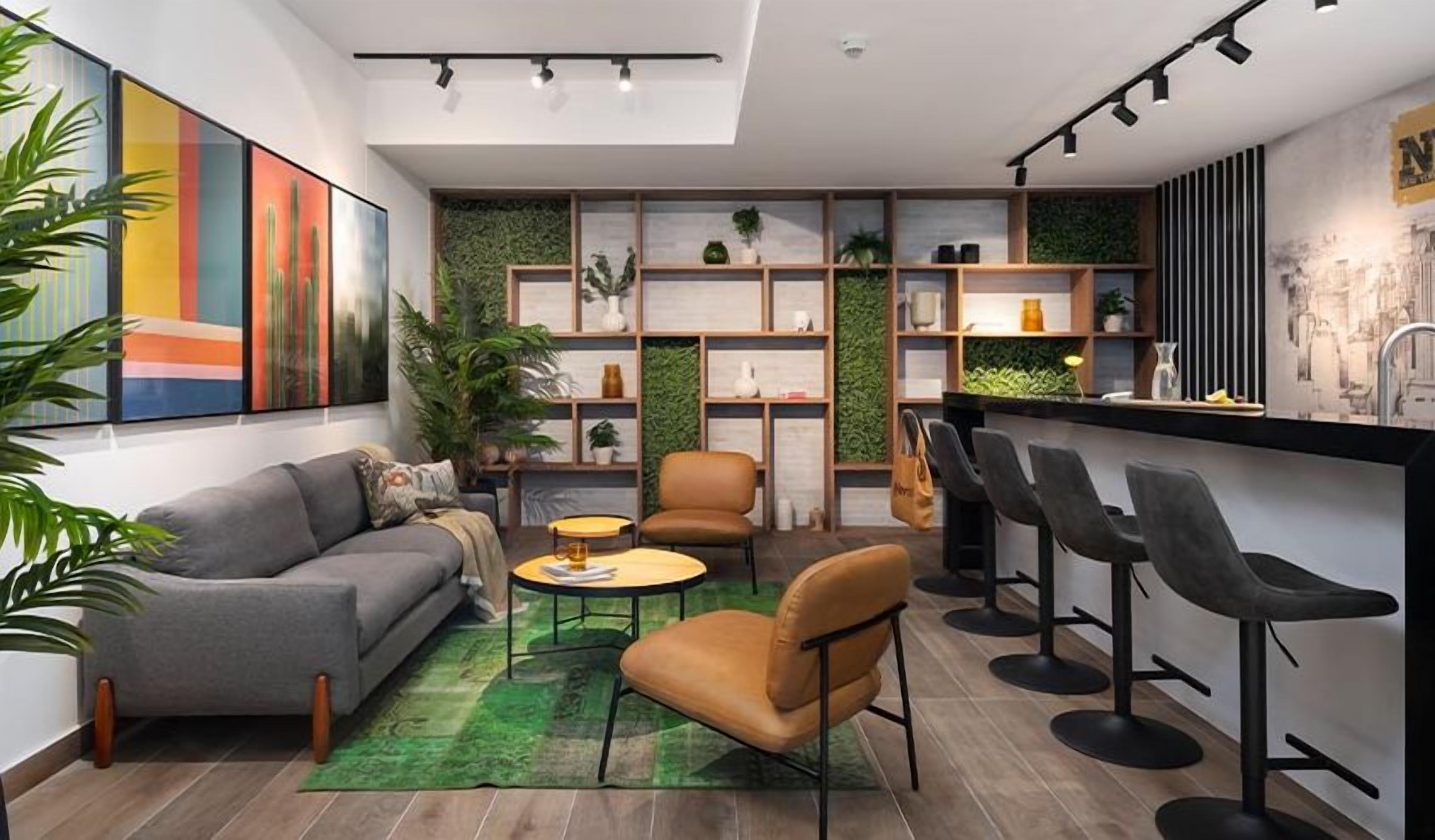 Una sala de estar moderna con sofá, sillones, una mesa de centro y una zona de bar con taburetes.
