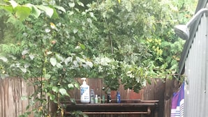 A wooden fence with a shelf holding toiletries.