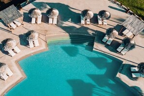 An aerial view of a pool area with lounge chairs and umbrellas. - Mitsis Rinela (Kokkini Hani)