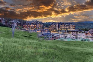 A multi-story lodge with a ski lift in the background, surrounded by a mountainous landscape. - Ski in / Ski out Grand Colorado Peak 8! Two Bedroom.  Sleeps 8. REDUCED PRICE!! (Breckenridge)