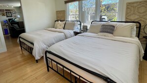 Un dormitorio con dos camas, un escritorio y una silla.