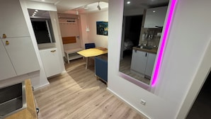 A modern kitchen with a dining area, a dramatic exit sign, and a mirror with pink LED lighting. - Smart, central apartment - garden - barbecue (Bückeburg)