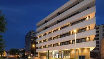 A multi-story hotel with a modern design, featuring a flat facade and evenly spaced windows.