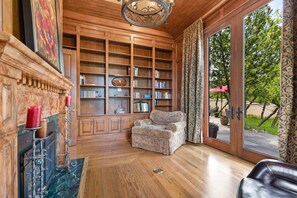 Relax in a traditional space with a fireplace, comfortable armchair, and sliding glass door to an outdoor area.