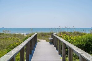 A wooden boardwalk leading to a beach with clear skies and calm waters. - Ocean View, 2 Primary Suites, Heated Pool, Beach (Cape Canaveral)