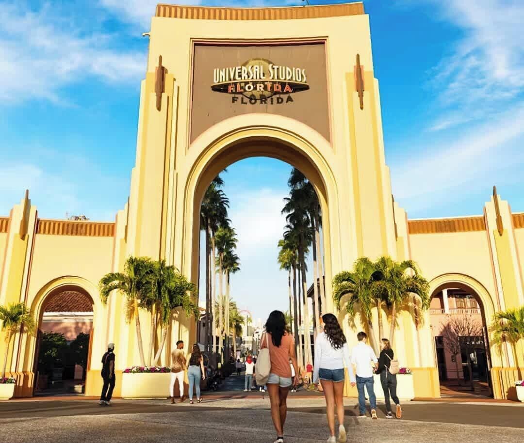 Ingången till Universal Studios Florida, med en stor valvformad portal och palmer.