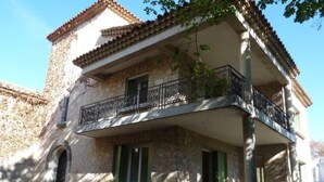 A two-story stone building with a balcony, stone walls, and a tiled roof. - Large villa 10 minutes from the Nîmes Arena (Nîmes)