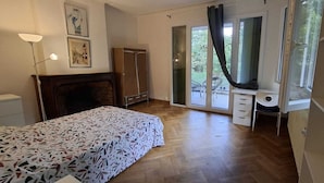A bedroom with a bed, a desk, a wardrobe, and a sliding glass door leading to a balcony. - Large villa 10 minutes from the Nîmes Arena (Nîmes)