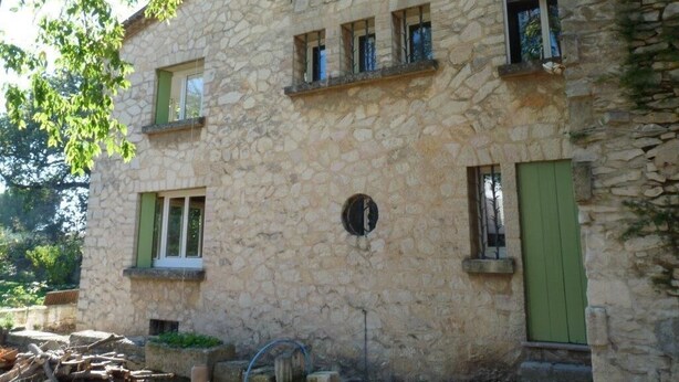 A stone building with multiple windows and a green door. - Large villa 10 minutes from the Nîmes Arena (Nîmes)