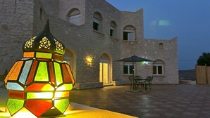 A stone building with a courtyard, a colorful lantern, and outdoor furniture. - Essaouira countryside, villa, swimming pool, 2 hectares, olive trees, mountain view, .... (essaouira)