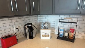 A kitchen with a toaster, coffee maker, and a coffee sign. - Gated 2BR in Greenville w/Vibes (Greenville)