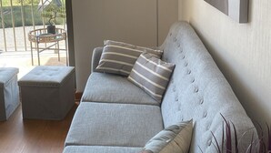 A modern living room with a grey sofa, striped pillows, a throw blanket, a floor lamp, and a large painting on the wall. - The most comfortable apartment in San Fernando (San Fernando)