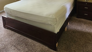 A neatly made bed in a room with a ceiling fan, a framed picture on the wall, and a nightstand with a lamp. - 3-bedroom condo in welcoming Kissimmee with WiFi, AC and Gated community. (Kissimmee)