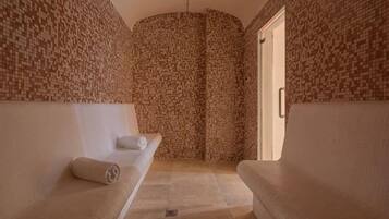 Un cuarto de spa con dos bancos, una pared con azulejos y una puerta.