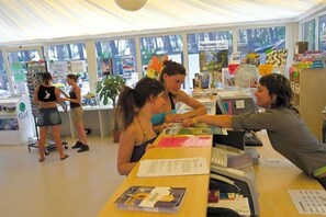 Una librería con mesas, sillas, libros y un mostrador.