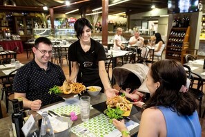 Un interior de restaurante con mesas, sillas y comensales.