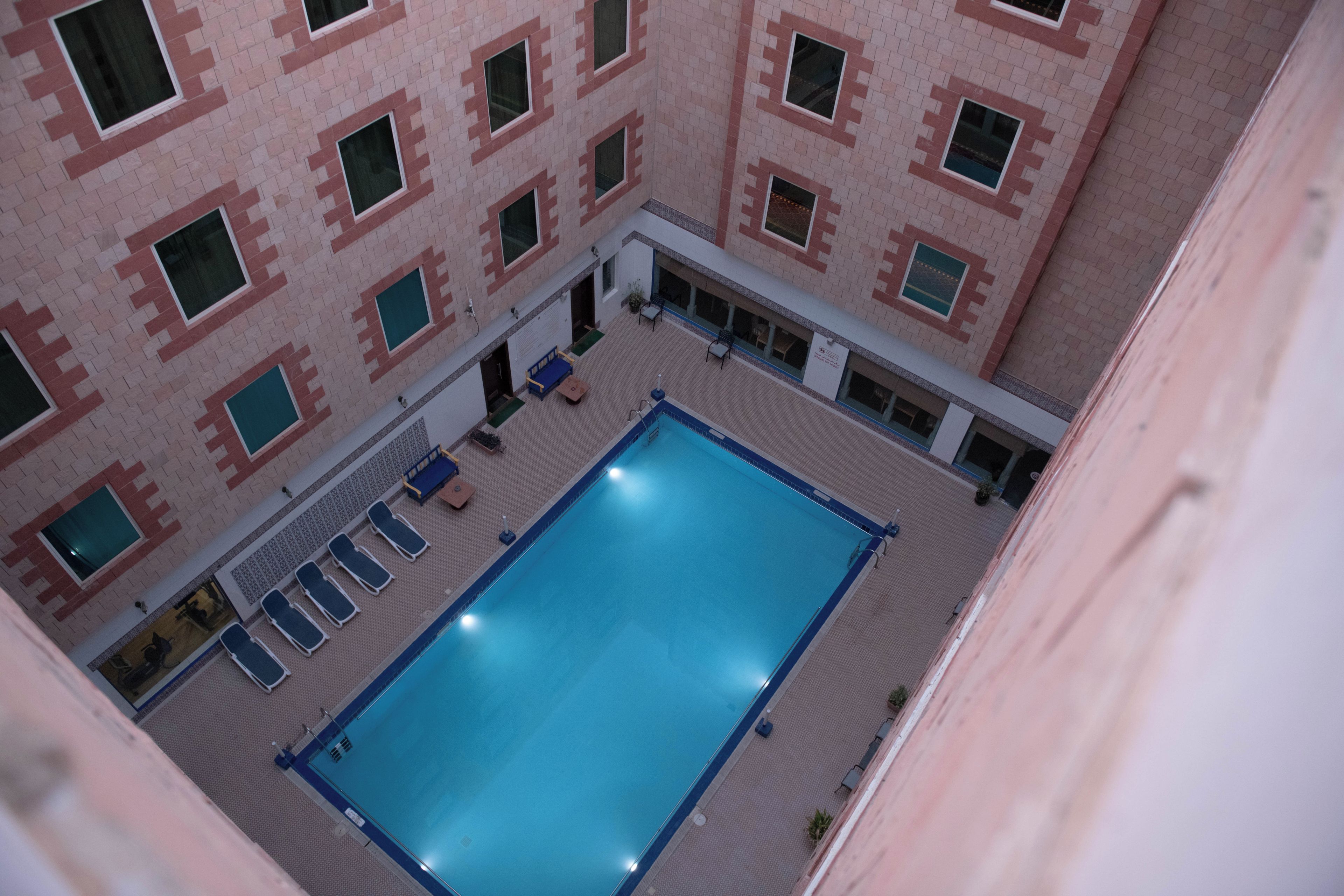 A rooftop pool with a clear view of the building's brick facade and multiple windows.