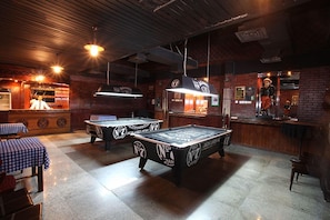 A billiards room with tables and a bar area. - Ramee Guestline Hotel (Muscat)