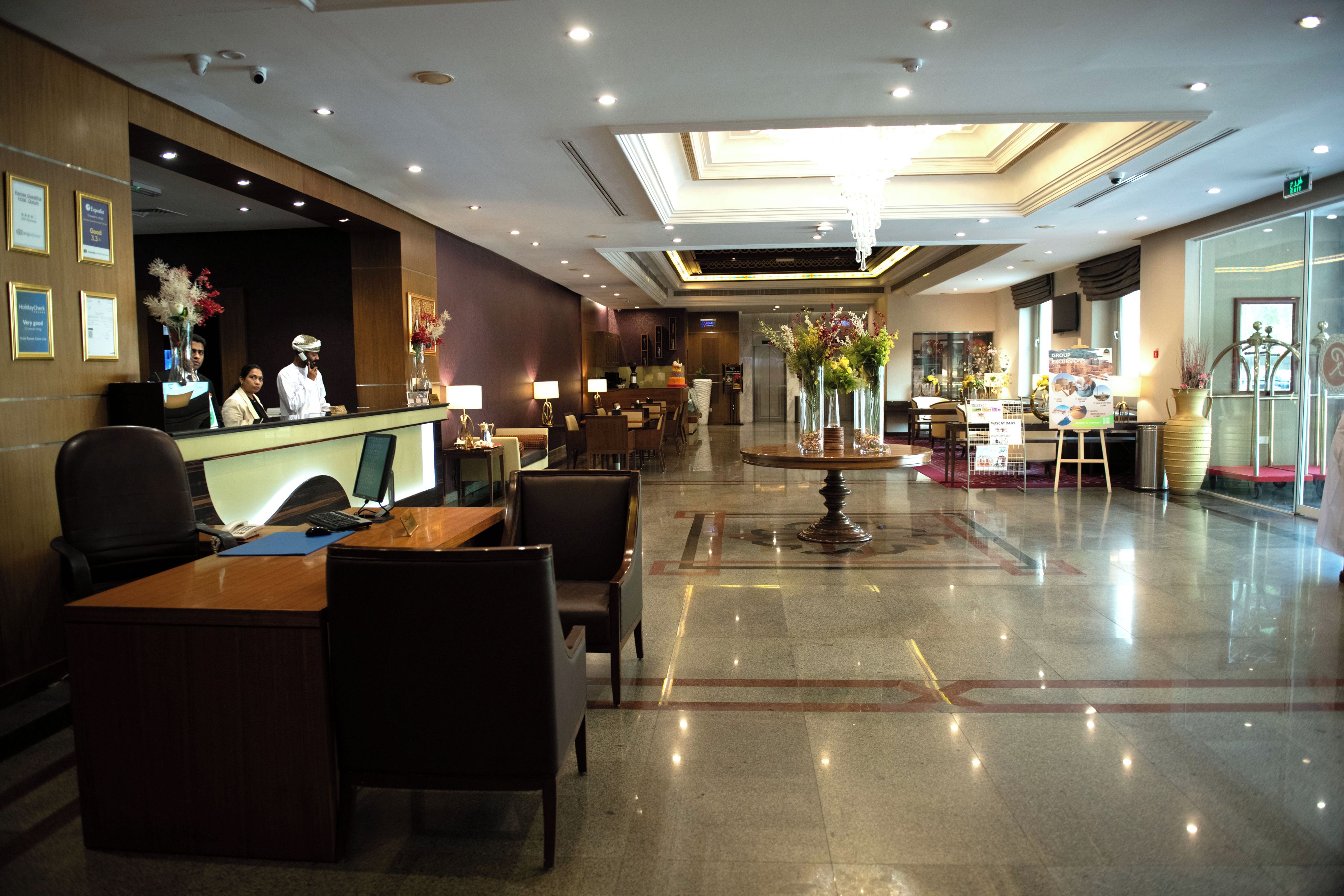 Un vestíbulo de hotel con mostrador de recepción, zona de estar y una fuente decorativa.