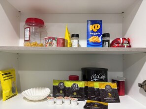 A shelf with various food items and coffee products.