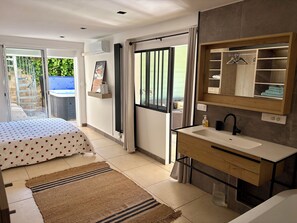 A modern bedroom with a bed, a bathroom with a sink and mirror, and a sliding glass door leading to a balcony. - Villa toulon air-conditioned panoramic sea view swimming pool jacuzzi sauna (Toulon)