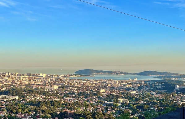 A panoramic view of a coastal city with dense urban development, a prominent hill, and a clear sky. - Villa toulon air-conditioned panoramic sea view swimming pool jacuzzi sauna (Toulon)