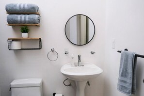 Chuveiro, toalhas de banho, sabonete, papel higiênico