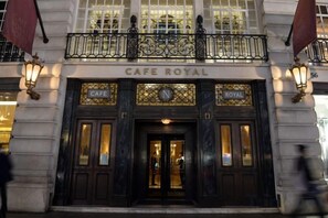 L’entrée du Café Royal, avec sa façade noire, ses ferronneries ouvragées et ses enseignes lumineuses.