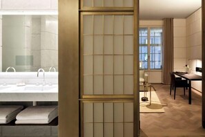 A modern bathroom with a large bathtub, a mirror, and a toilet. - Hotel Cafe Royal (London)