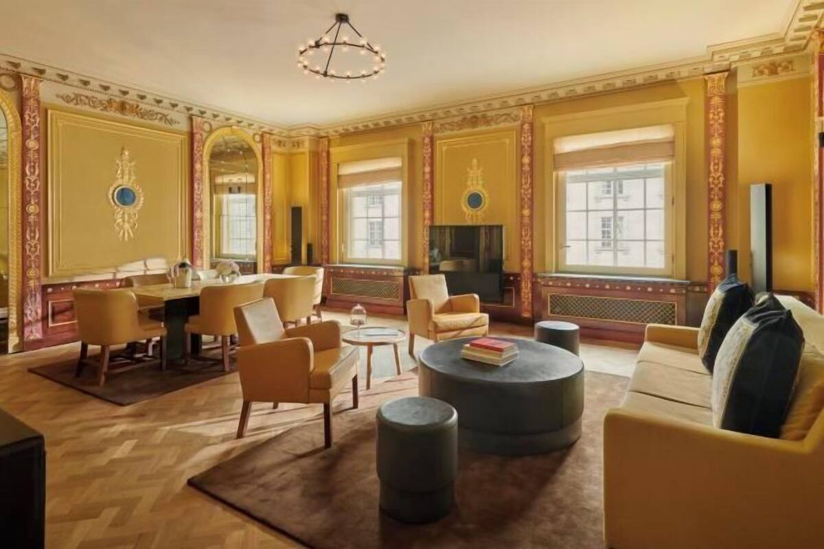 A spacious living room with a large round coffee table, comfortable seating, and a fireplace.