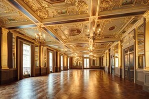 A long, ornate hallway with high ceilings and chandeliers. - Hotel Cafe Royal (London)