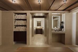 A hallway with a wooden ceiling, a mirror, and a shelf with towels. - Hotel Cafe Royal (London)