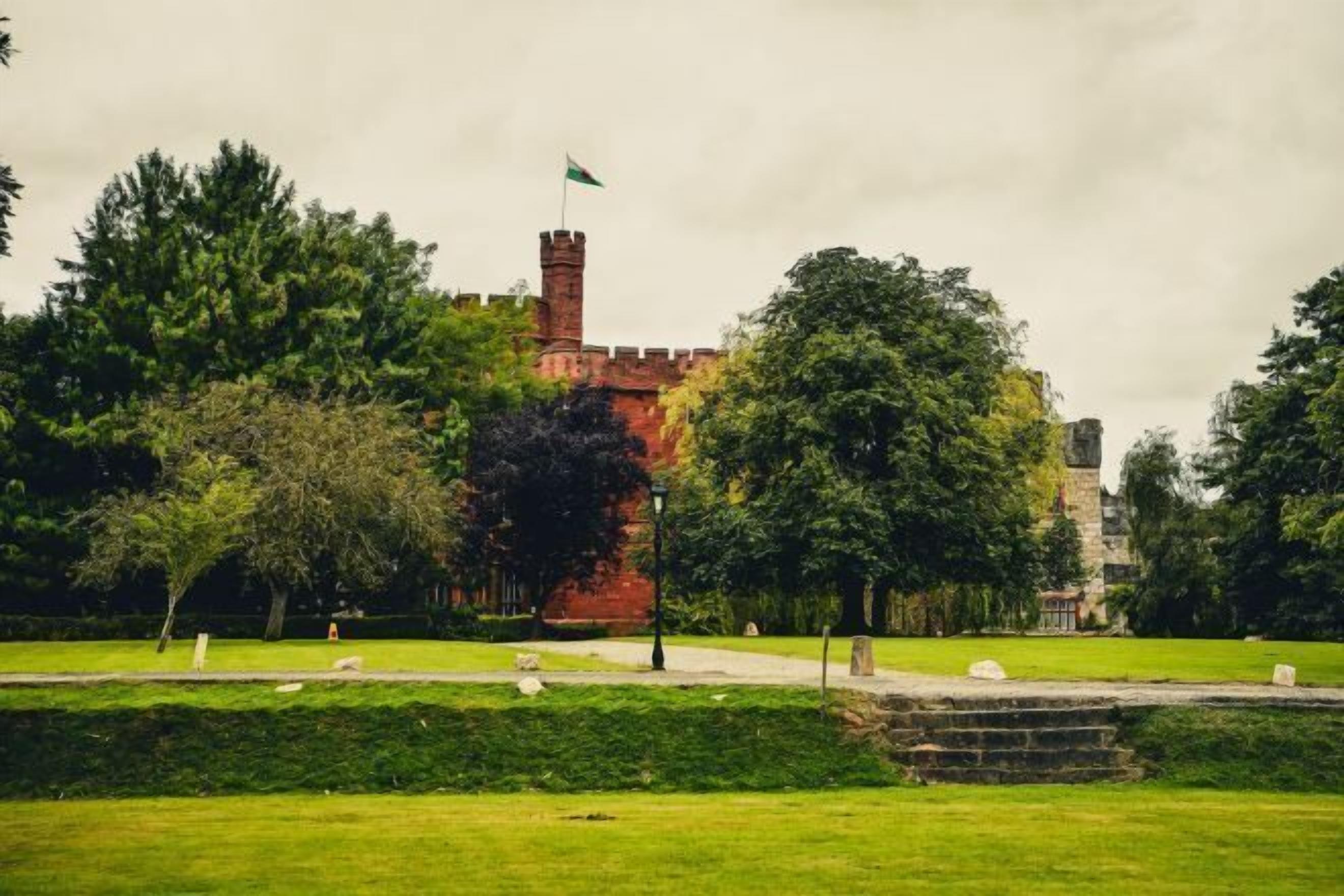 A castle-like structure with a flag, surrounded by lush greenery and a well-maintained lawn.