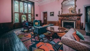 A room with a large window, a fireplace, and a patterned rug. - Cbh Ruthin Castle Hotel and Spa (Ruthin)