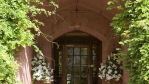 A brick archway with a wooden door, surrounded by green foliage. - Cbh Ruthin Castle Hotel and Spa (Ruthin)